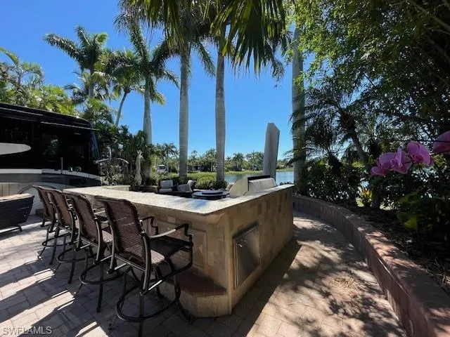 View of patio / terrace with an outdoor kitchen and a water view