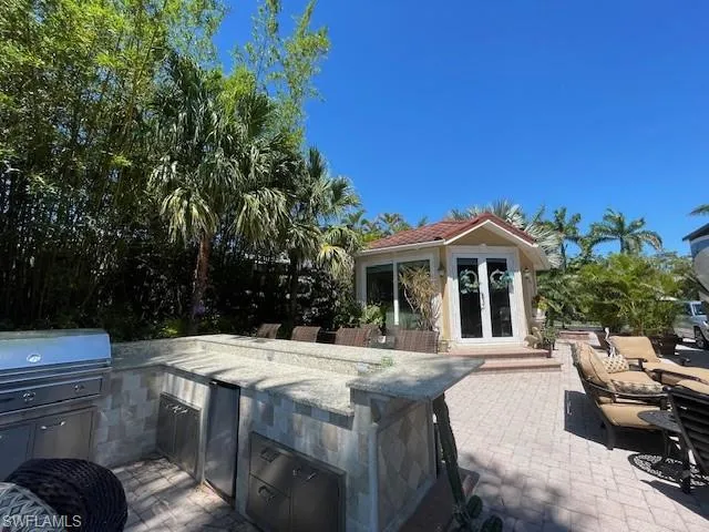 View of patio / terrace featuring an outdoor kitchen, an outbuilding, and french doors