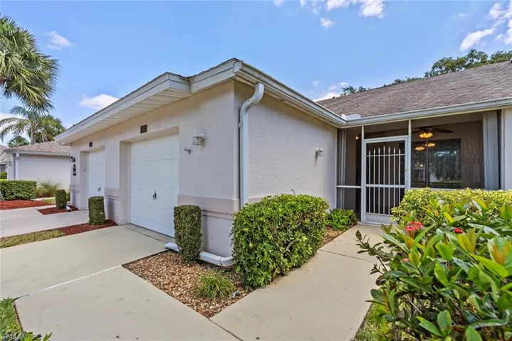 View of home's exterior with an attached one car garage and front screened lanai entry