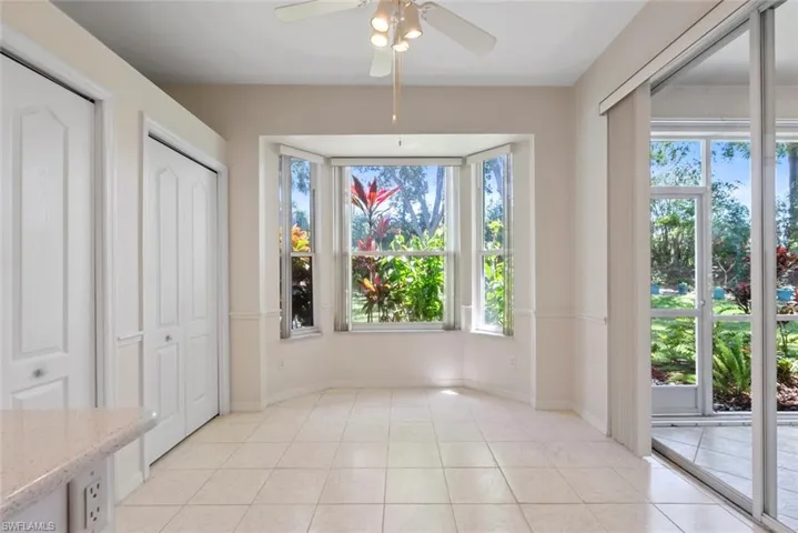 Unfurnished dining area featuring light tile patterned floors, baseboards, and a ceiling fan