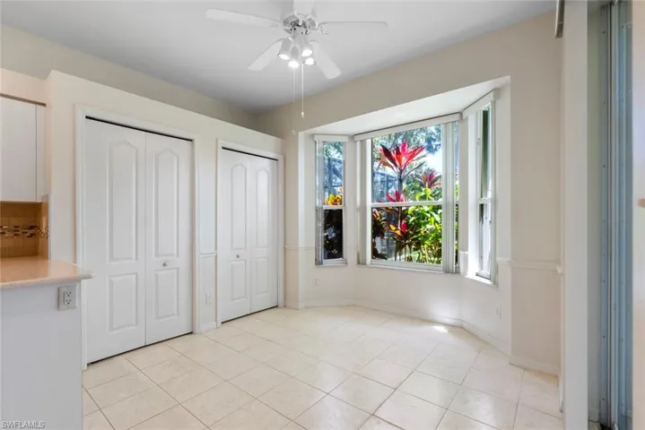 Unfurnished bedroom featuring light tile patterned flooring, baseboards, a ceiling fan, and multiple closets