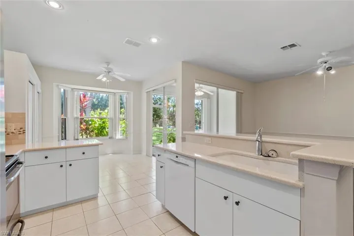 Kitchen with stainless steel electric range, white dishwasher, visible vents, and a ceiling fan