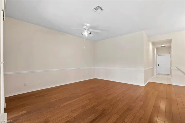 Empty room with visible vents, baseboards, a ceiling fan, and light wood-style floors