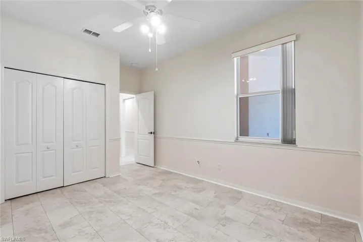 Unfurnished bedroom featuring visible vents, a closet, baseboards, and ceiling fan