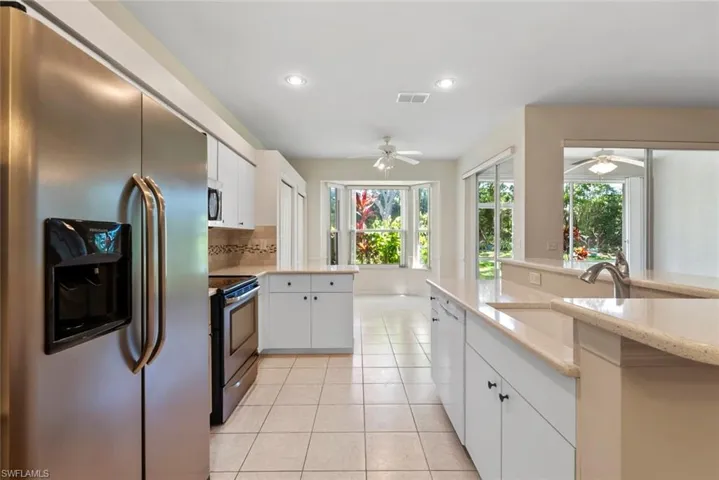 Kitchen featuring visible vents, a sink, ceiling fan, appliances with stainless steel finishes, and light tile patterned flooring