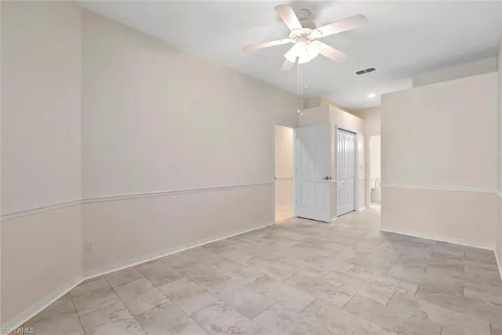 Unfurnished room with visible vents, ceiling fan, and baseboards