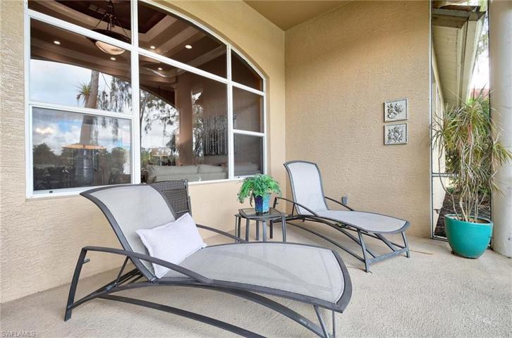 lanai on back of home with views of lake and golf course