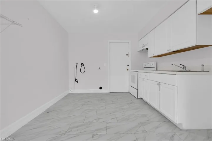 Laundry area with light marble finish flooring, hookup for an electric dryer, and washer hookup