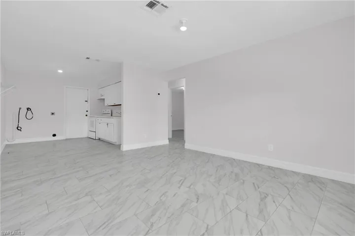 Unfurnished living room featuring baseboards