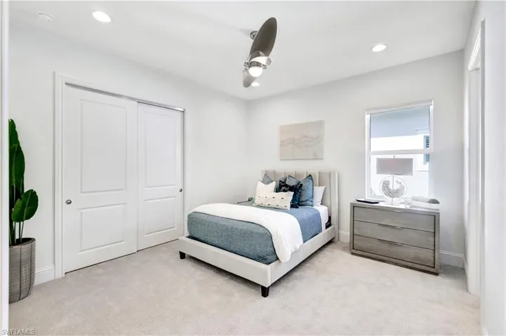 Carpeted bedroom with ceiling fan, recessed lighting, and a closet