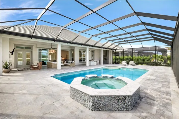 View of swimming pool featuring a sunroom, a pool with connected hot tub, an outdoor hangout area, glass enclosure, and a patio
