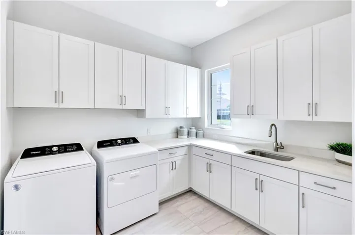 Laundry room featuring independent washer and dryer, cabinet space, and recessed lighting