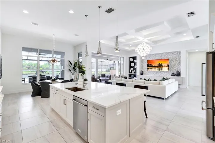 Kitchen featuring a chandelier, open floor plan, hanging light fixtures, coffered ceiling, and recessed lighting