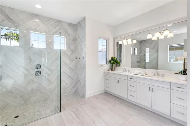 Bathroom featuring double vanity, walk in shower, and recessed lighting