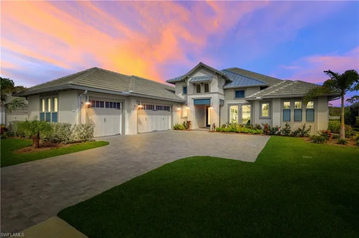 View of front facade with a garage, decorative driveway, and stucco siding