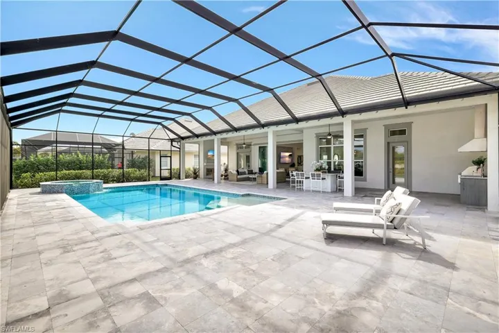 View of pool featuring a sunroom, glass enclosure, and a patio area