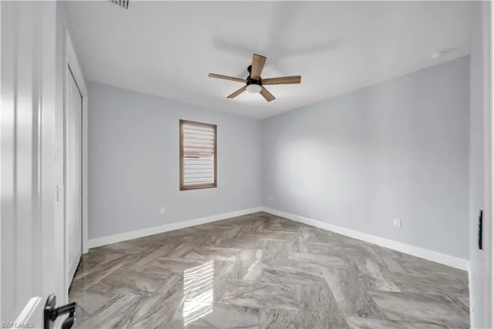 Spare room featuring ceiling fan and baseboards