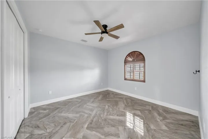 Unfurnished bedroom with a closet, baseboards, a ceiling fan, and visible vents