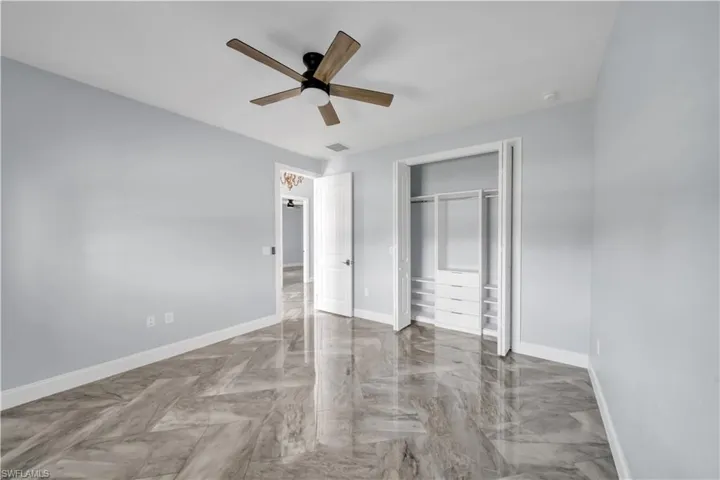 Unfurnished bedroom featuring a closet, marble finish floor, visible vents, and baseboards