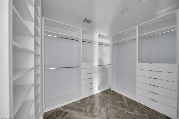 Walk in closet featuring visible vents and marble finish floor