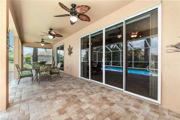 View of patio with a ceiling fan, outdoor dining space, and an outdoor pool