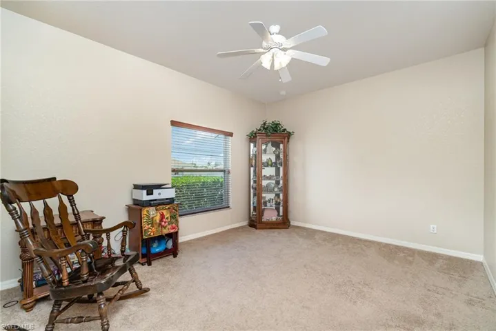 Sitting room featuring light colored carpet, ceiling fan, and baseboards