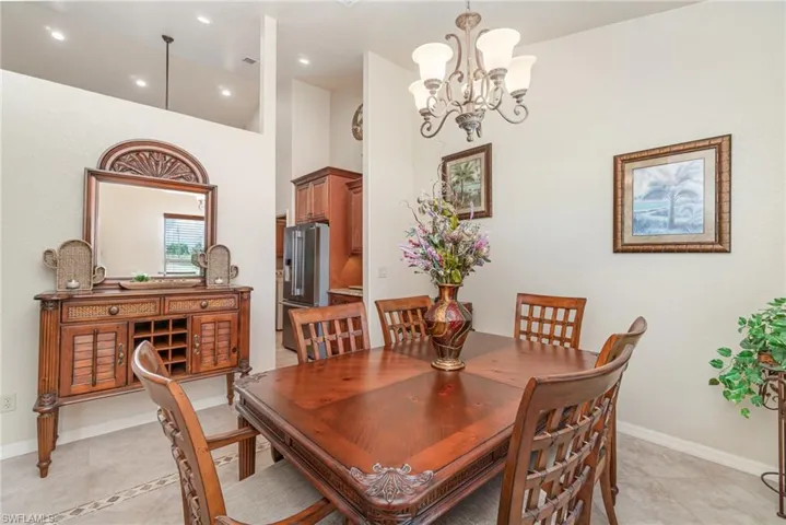 Dining room featuring a chandelier, light tile patterned floors, recessed lighting, and baseboards
