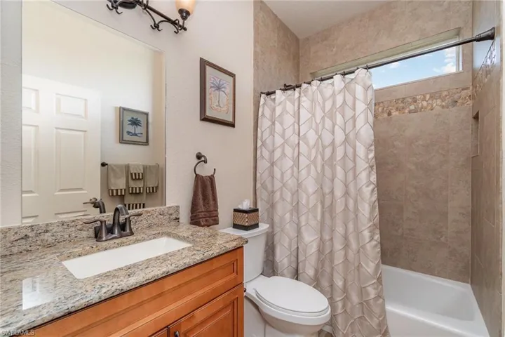 Full bath with toilet, vanity, and shower / bathtub combination with curtain