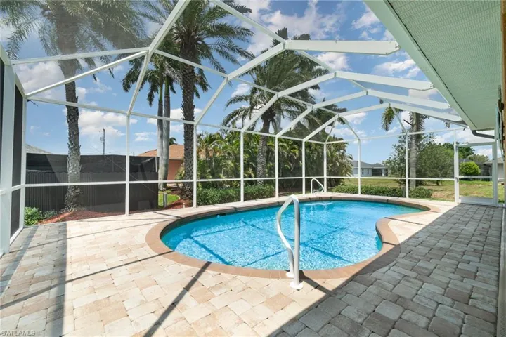Swimming pool with a patio and glass enclosure