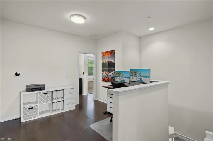 Loft area for den or office use with dark hardwood flooring
