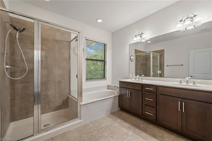 Owners Ensuite Bathroom with tile flooring, bathtub plus walk in shower, and double sink vanity
