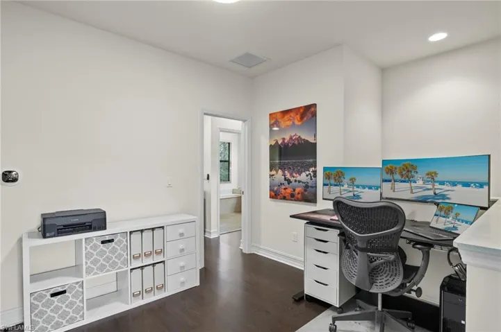 Loft area for den or office use featuring dark hardwood flooring
