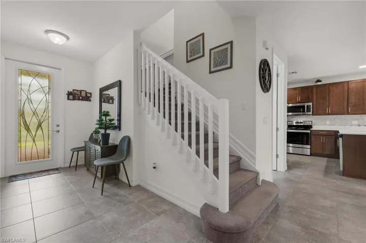 Spacious front foyer, featuring designer glass insert front door allowing ample lighting into the home