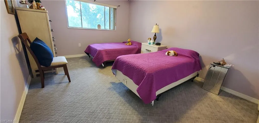 Bedroom with baseboards and light colored carpet