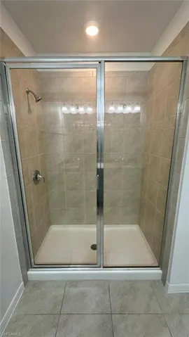 Full bathroom featuring a stall shower and light tile patterned floors