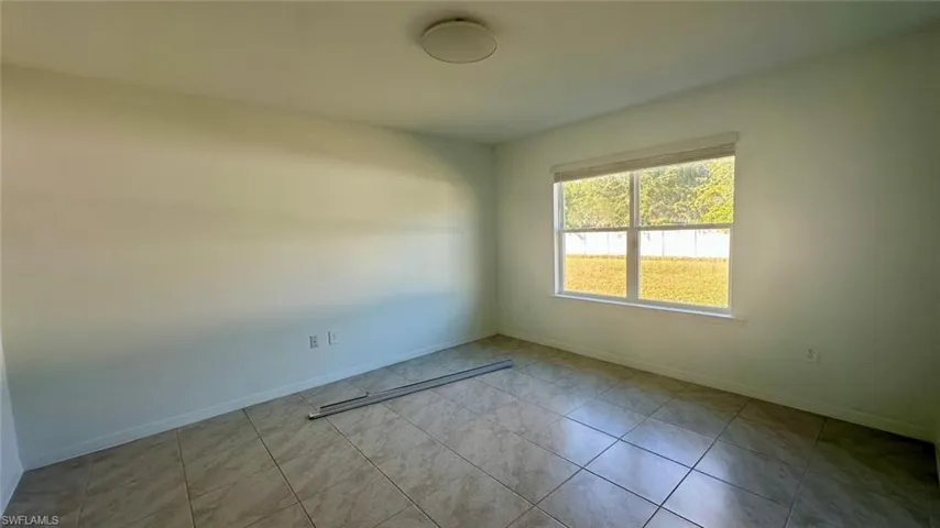 Spare room with baseboards and light tile patterned flooring