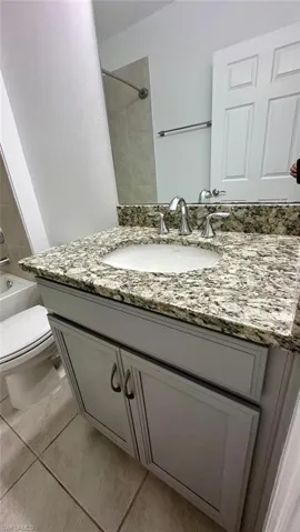 Bathroom featuring vanity, bathtub / shower combination, and light tile patterned floors
