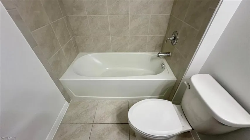 Bathroom featuring tile patterned flooring and bathing tub / shower combination