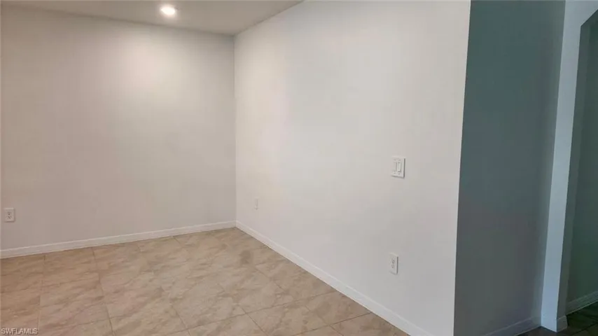 Unfurnished room with baseboards and light tile patterned flooring