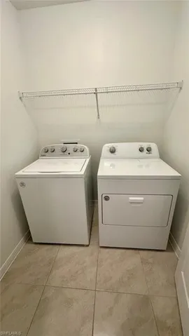 Washroom featuring light tile patterned floors and washer and dryer