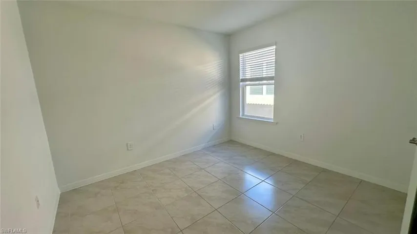 Spare room featuring baseboards and light tile patterned flooring