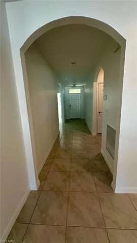 Hallway featuring baseboards and light tile patterned flooring