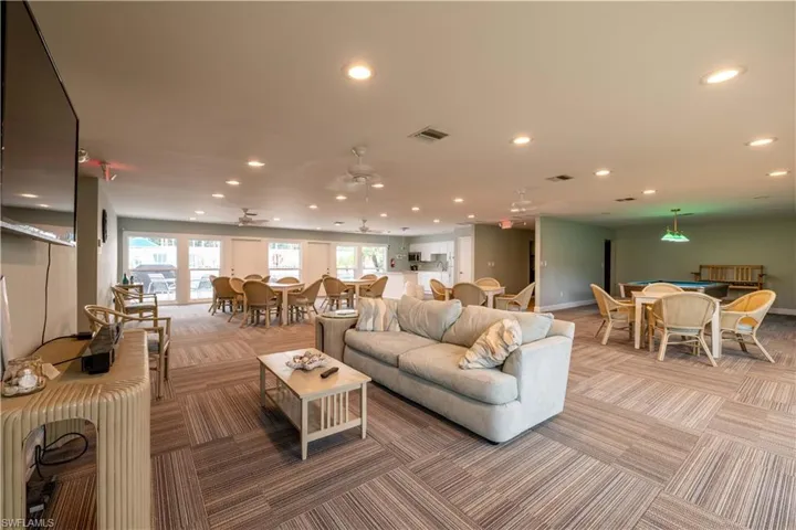 Living room with carpet flooring and ceiling fan