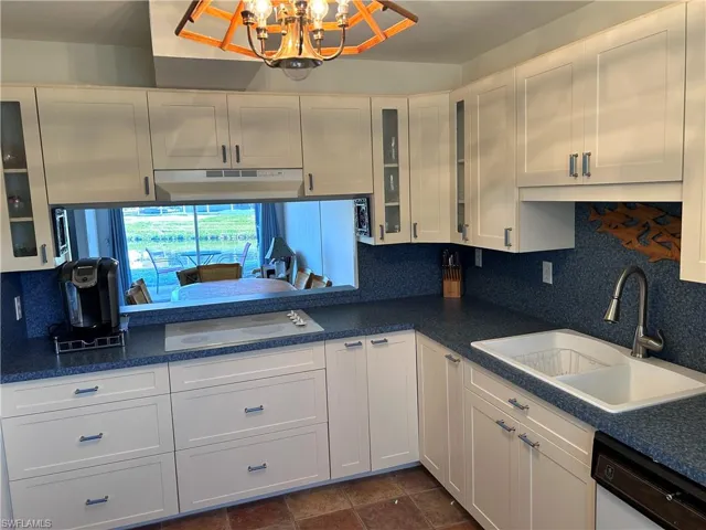 Kitchen featuring white cabinetry, white appliances, sink, and decorative backsplash