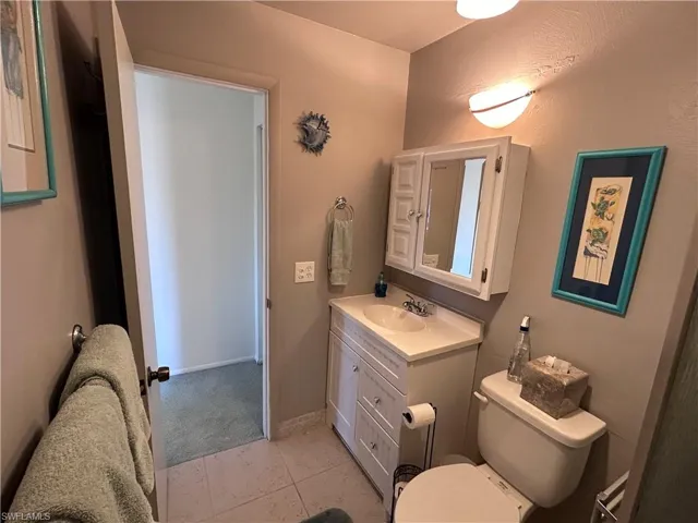 Bathroom featuring vanity, toilet, and tile patterned flooring
