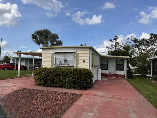 View of front of home featuring a carport and a front yard