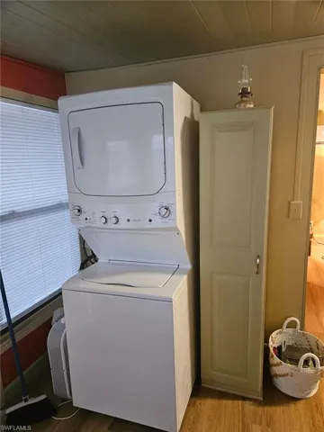 Laundry area with stacked washer and dryer, storage cabinet