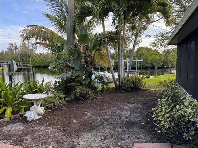 View of yard with a water view and a boat dock