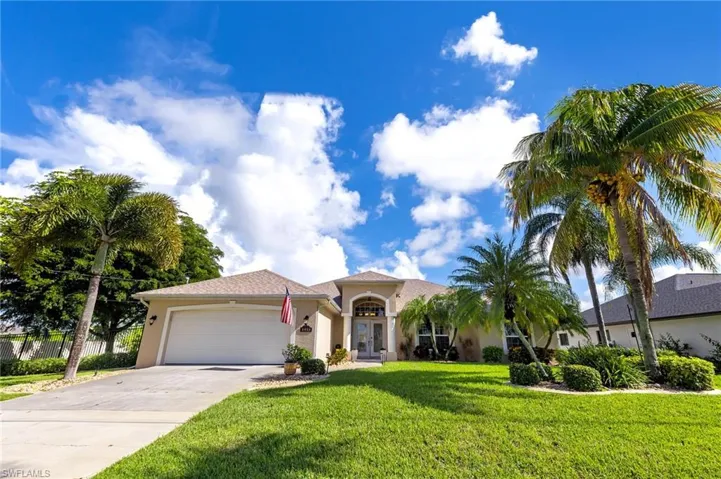 View of front of home featuring stucco siding, driveway, a garage, and a front lawn