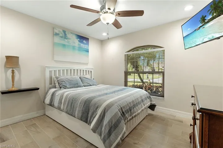 Bedroom with wood tiled floors, a ceiling fan, and recessed lighting